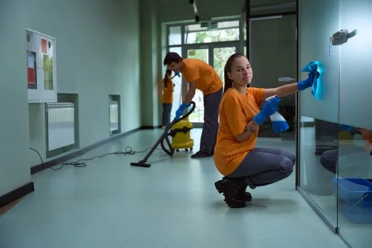 Staff Team of cleaning professionals in matching orange uniforms